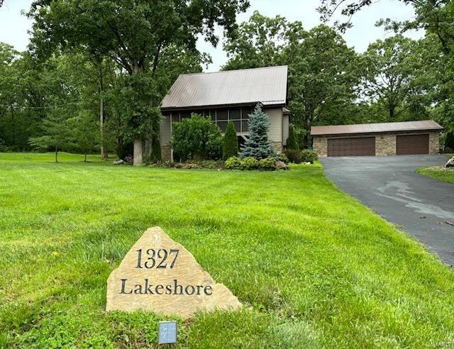 view of front facade with a garage, an outbuilding, and a front yard