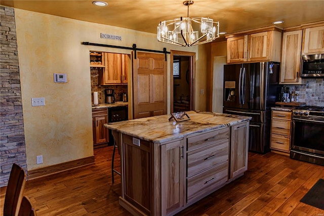 kitchen featuring gas stove, a barn door, a kitchen island, backsplash, and dark wood-type flooring