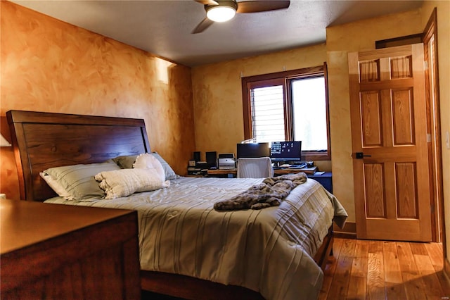 bedroom with light hardwood / wood-style floors and ceiling fan