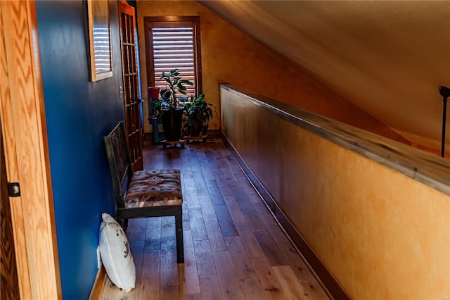 corridor featuring lofted ceiling and dark hardwood / wood-style flooring