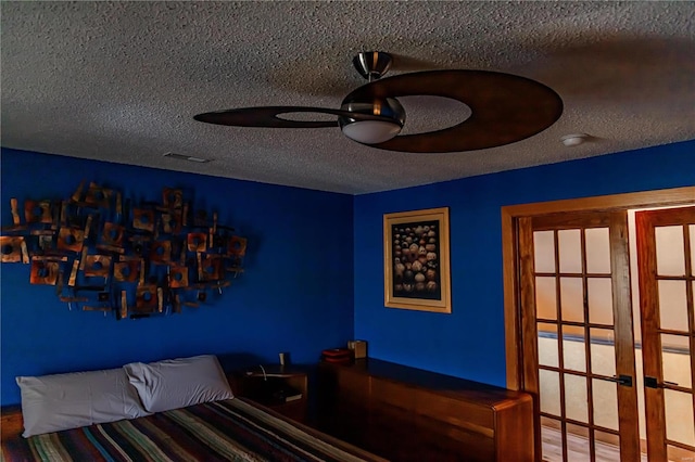 unfurnished bedroom with a textured ceiling, ceiling fan, and french doors