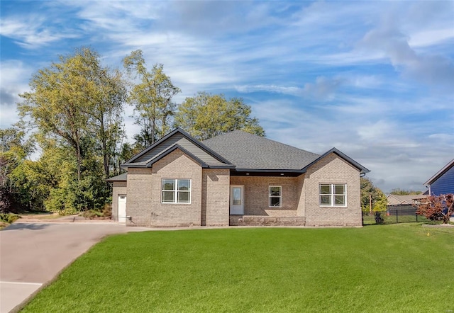 single story home with brick siding, a shingled roof, concrete driveway, fence, and a front lawn