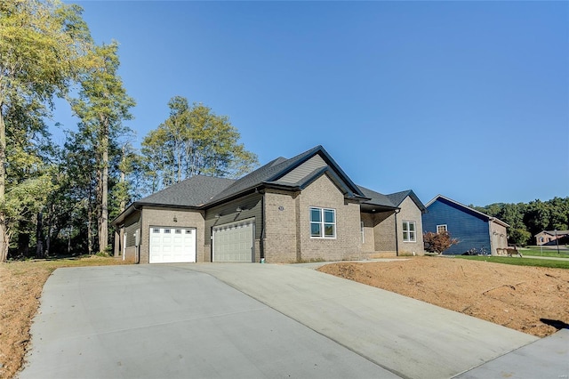 view of front of home with a garage, driveway, and brick siding