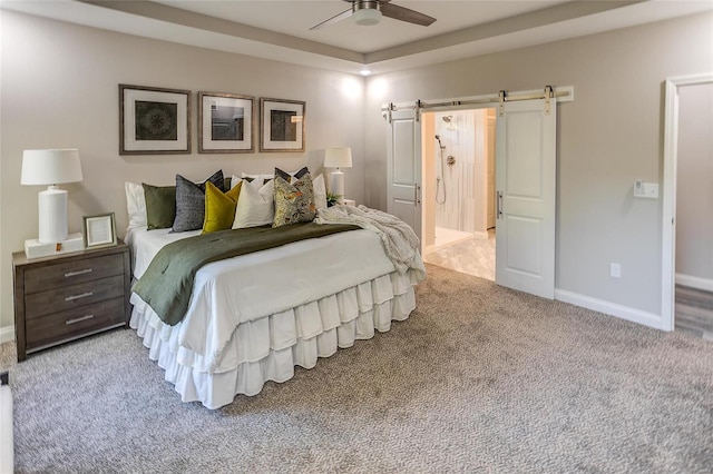 bedroom featuring light carpet, ceiling fan, and a barn door