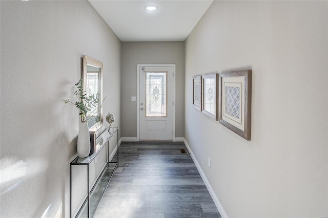 entryway with dark wood-type flooring and baseboards