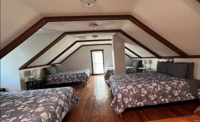 bedroom with dark hardwood / wood-style floors and lofted ceiling