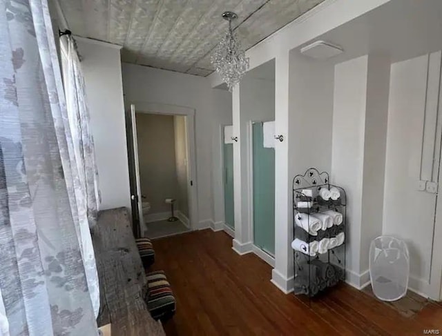 hall with a chandelier and dark hardwood / wood-style flooring