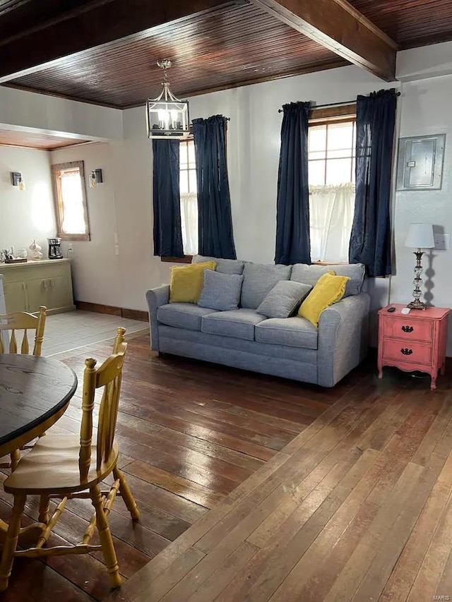 living room with plenty of natural light, dark hardwood / wood-style floors, wooden ceiling, and a chandelier