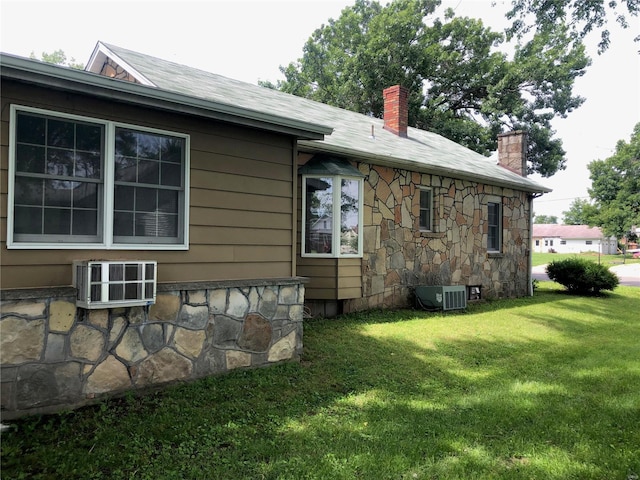 view of property exterior with a yard and central AC unit