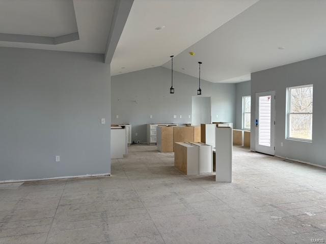 kitchen with light brown cabinetry, vaulted ceiling, and a kitchen island