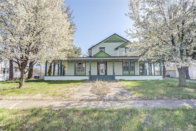 country-style home featuring covered porch and a front lawn