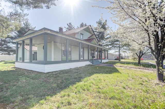 view of side of home with a porch and a lawn