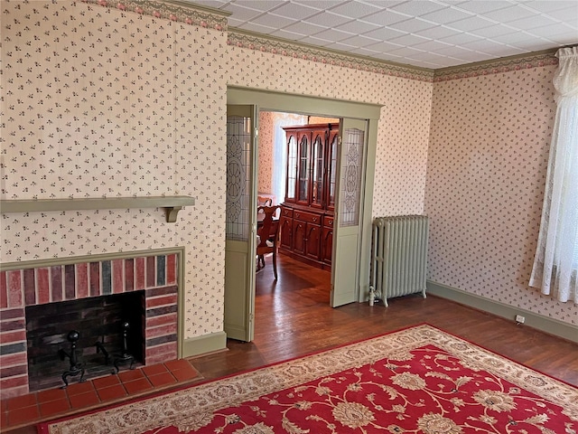 interior space featuring a brick fireplace, dark wood-type flooring, and radiator