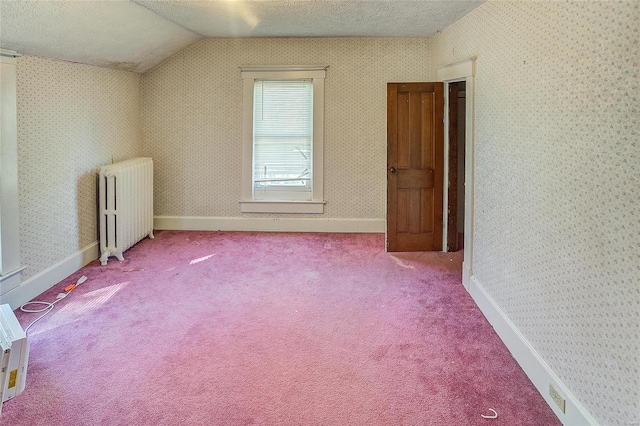 interior space with lofted ceiling, a textured ceiling, radiator, and light colored carpet