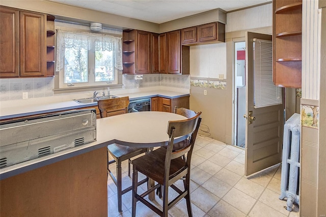 kitchen featuring light tile floors, backsplash, and sink