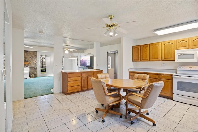 kitchen featuring a textured ceiling, white appliances, light tile patterned floors, and ceiling fan