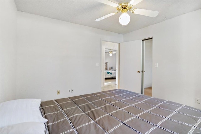 unfurnished bedroom with ceiling fan, a textured ceiling, and a closet