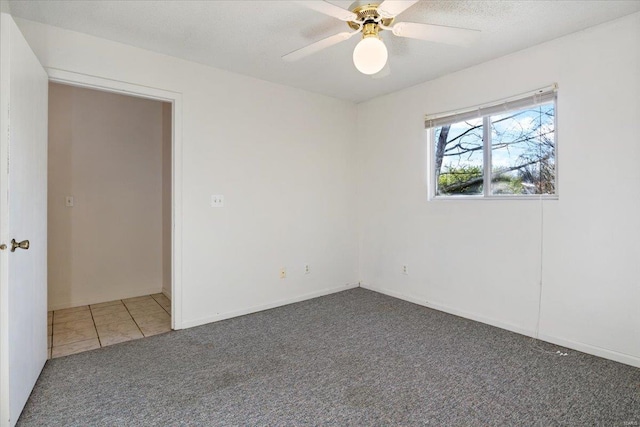 unfurnished room with dark colored carpet and ceiling fan