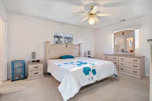 carpeted bedroom with a textured ceiling and ceiling fan