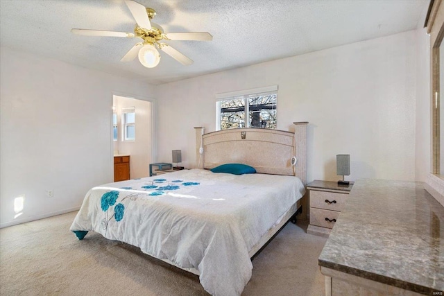 bedroom with ceiling fan, light colored carpet, and a textured ceiling