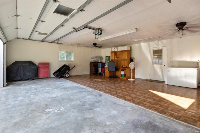 garage with ceiling fan, refrigerator, and a garage door opener