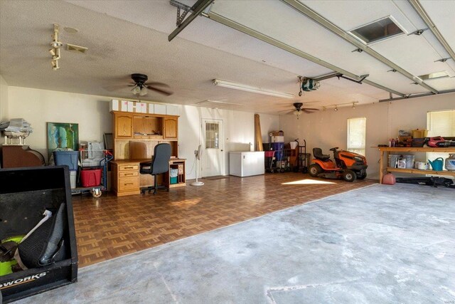 garage with a garage door opener and ceiling fan