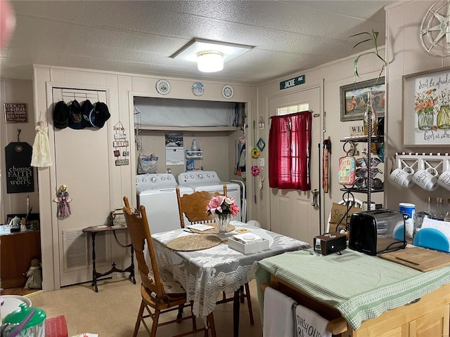 dining space featuring independent washer and dryer, light colored carpet, and a textured ceiling