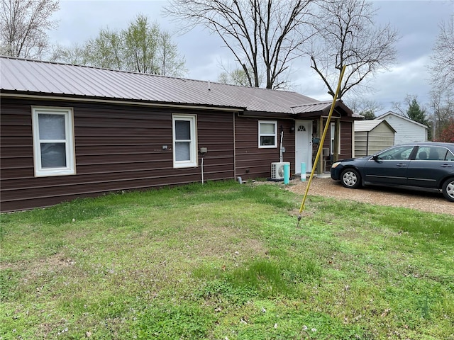 view of front of house with a front yard and central air condition unit