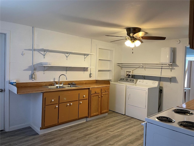 kitchen featuring ceiling fan, white electric stove, washer and dryer, light wood-type flooring, and sink