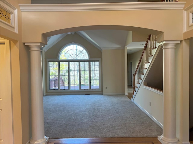 carpeted entryway with lofted ceiling and ornate columns