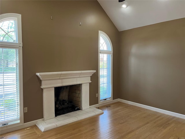 unfurnished living room with a healthy amount of sunlight, light hardwood / wood-style floors, and a tiled fireplace