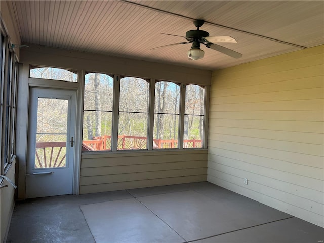 unfurnished sunroom with wood ceiling and ceiling fan