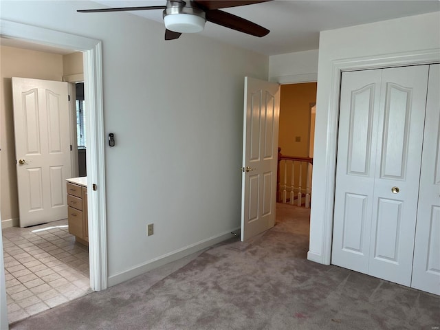 unfurnished bedroom with light tile floors, a closet, and ceiling fan