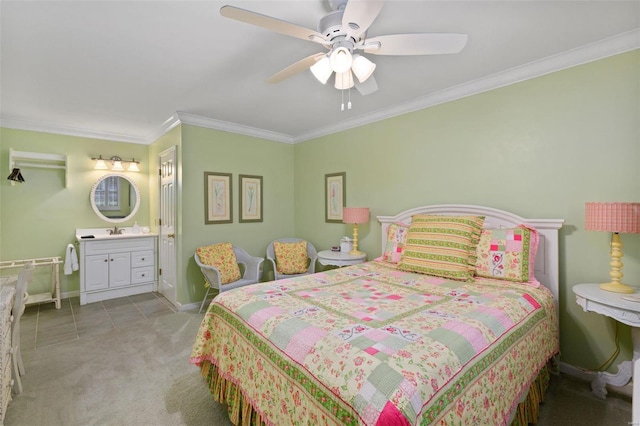 carpeted bedroom featuring ornamental molding, ensuite bath, sink, and ceiling fan