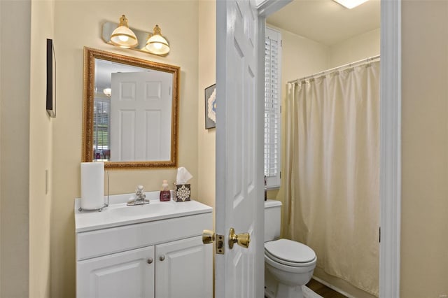 bathroom featuring vanity, toilet, and curtained shower