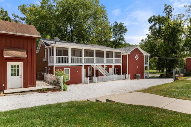 back of property with central AC, a lawn, and a sunroom