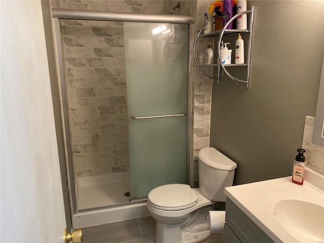 bathroom featuring toilet, tile flooring, walk in shower, and vanity