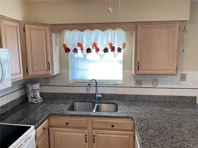 kitchen with backsplash, light brown cabinetry, and sink