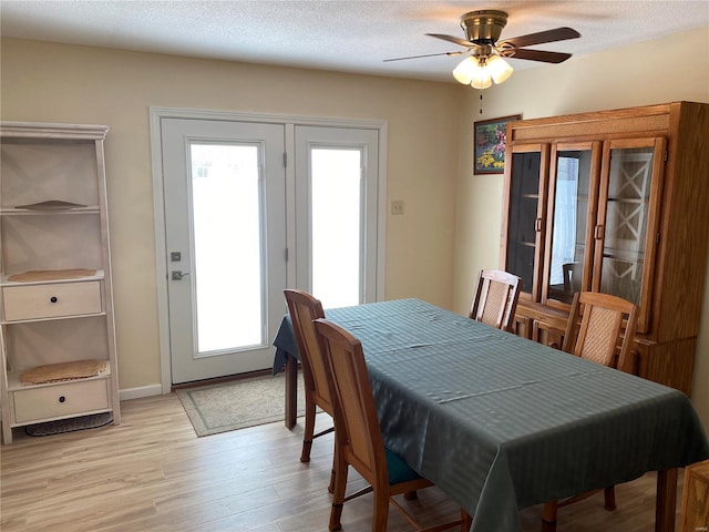 dining room featuring ceiling fan, a textured ceiling, and light hardwood / wood-style floors