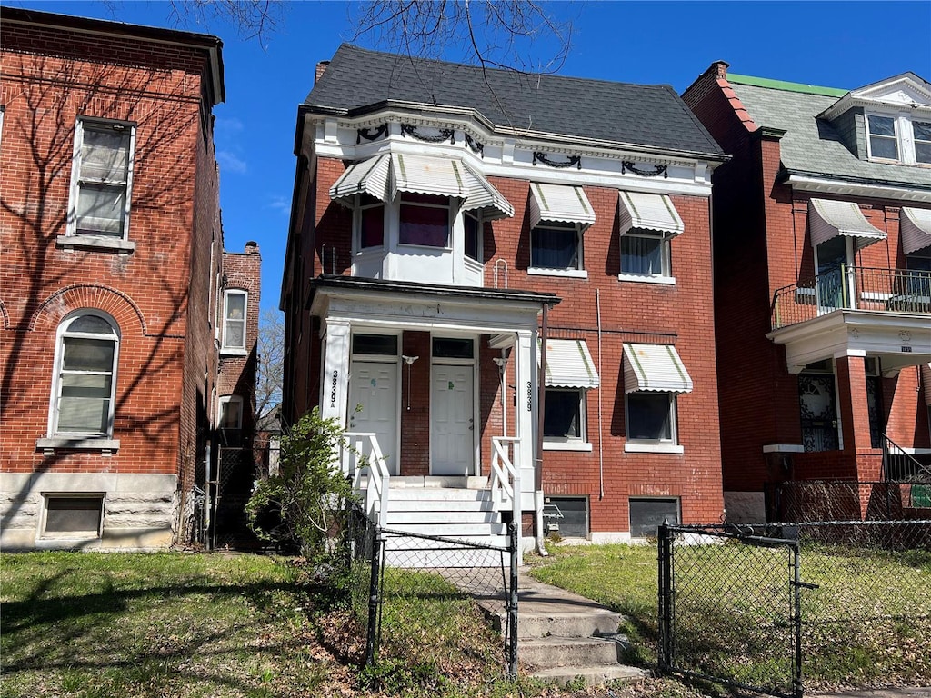 view of front of property with a balcony and a front lawn