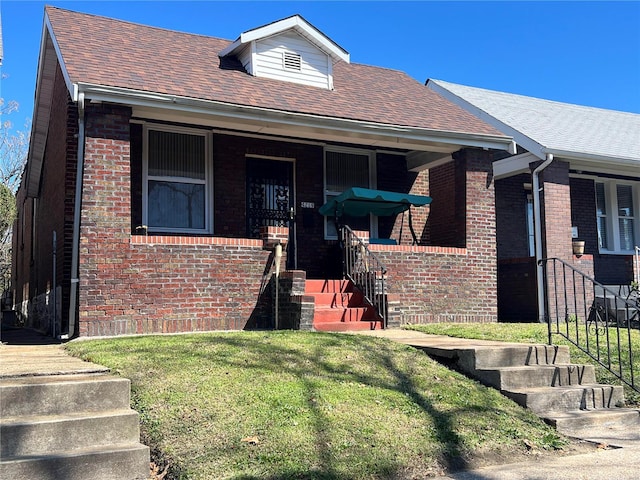 bungalow-style house featuring covered porch and a front lawn