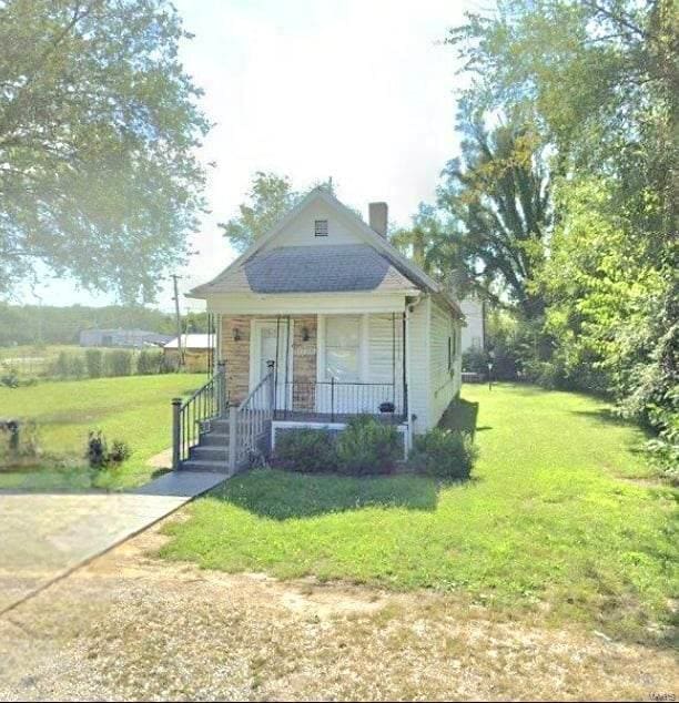 bungalow-style home with covered porch and a front yard