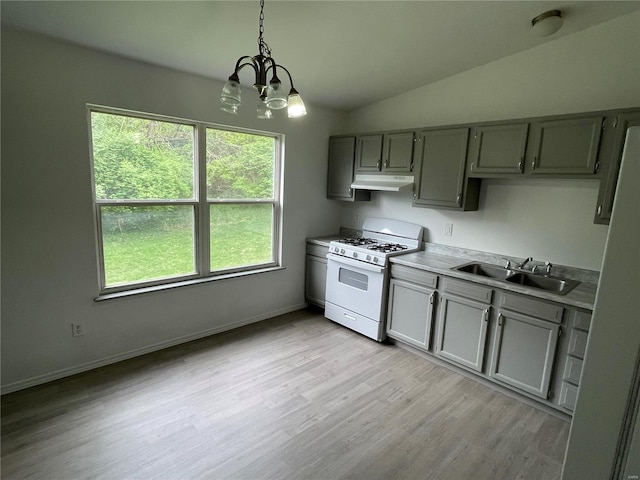 kitchen featuring lofted ceiling, sink, decorative light fixtures, white gas stove, and a chandelier