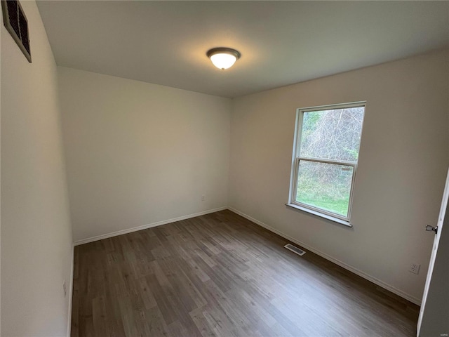 unfurnished room with dark hardwood / wood-style flooring and a wealth of natural light