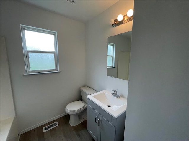 bathroom featuring vanity, toilet, plenty of natural light, and wood-type flooring