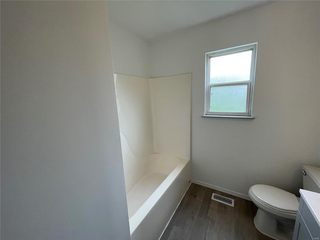 full bathroom with hardwood / wood-style floors, vanity, shower / bath combination, and toilet