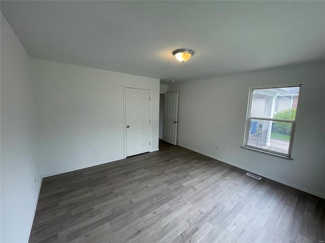 spare room with dark wood-type flooring