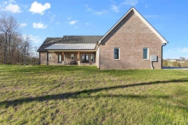 rear view of house featuring a yard