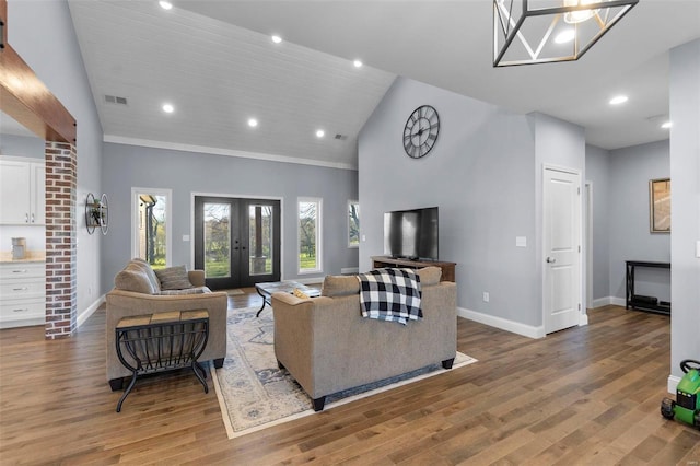 living room with high vaulted ceiling, brick wall, french doors, light hardwood / wood-style flooring, and crown molding