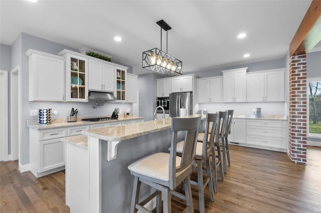 kitchen with stainless steel fridge, hanging light fixtures, dark hardwood / wood-style floors, and white cabinetry